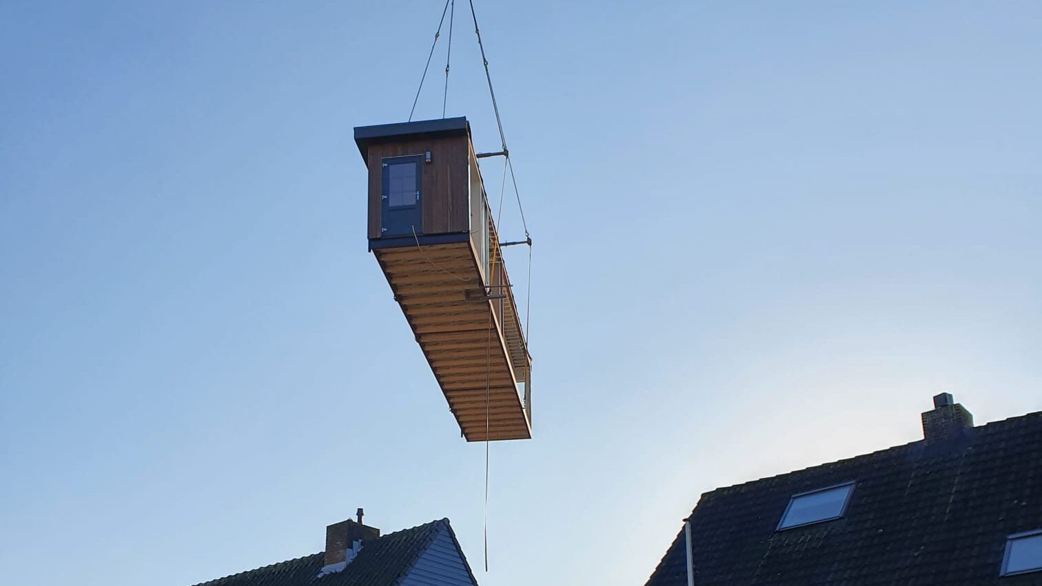 Modulaire unit wordt met telekraan op de fundering geplaatst tijdens een modulair bouwproject
