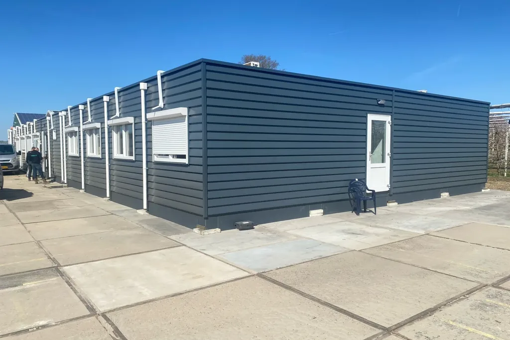 Anthraciet afgewerkte modulaire kantoorunit op een verharde projectlocatie