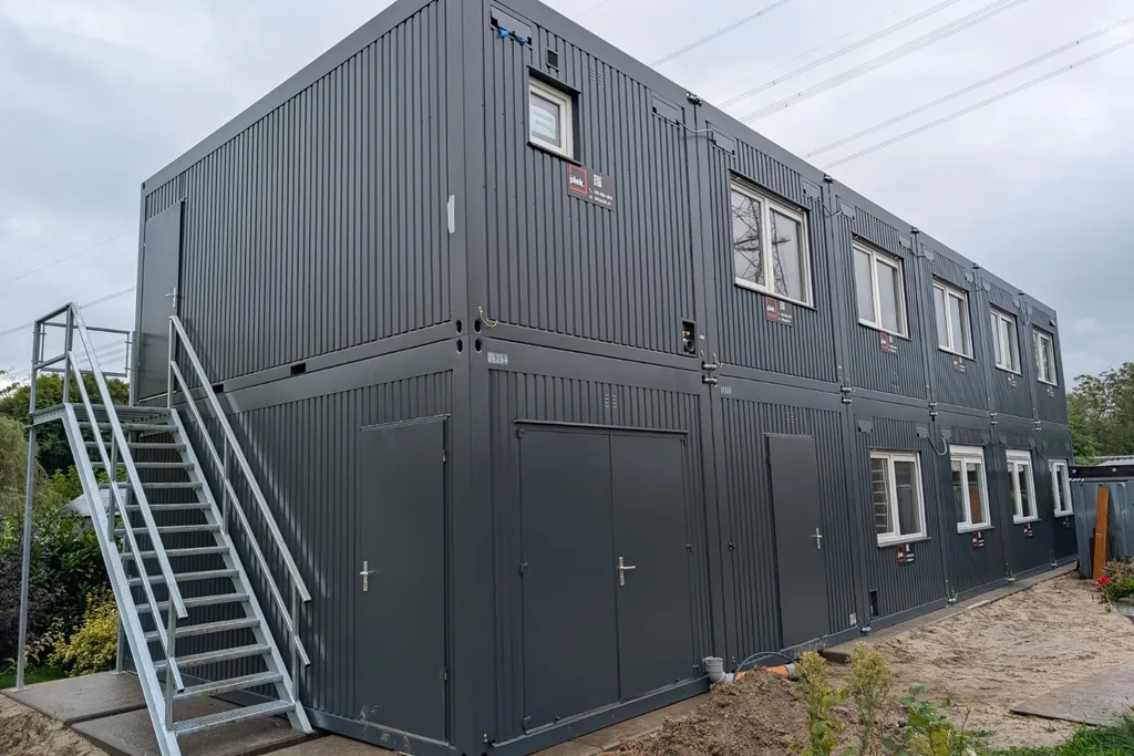 Gestapelde modulaire units met externe trap, voorbeeld van optoppen als manier om een modulair gebouw uit te breiden