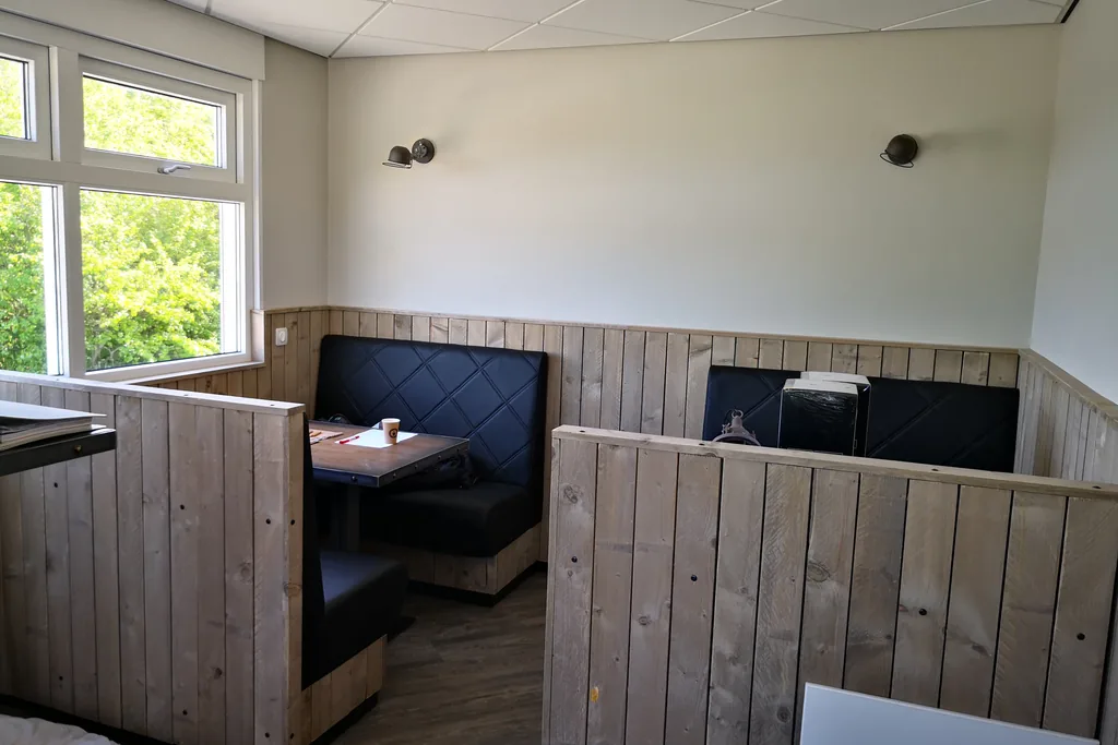 Modulair restaurant interieur met houten booth-seating en leren banken voor cozy dining